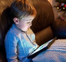 enfant devant un écran sur un canapé